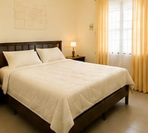 A restful Eazi Days bedroom — made-up double bed, lamps and soft curtains
